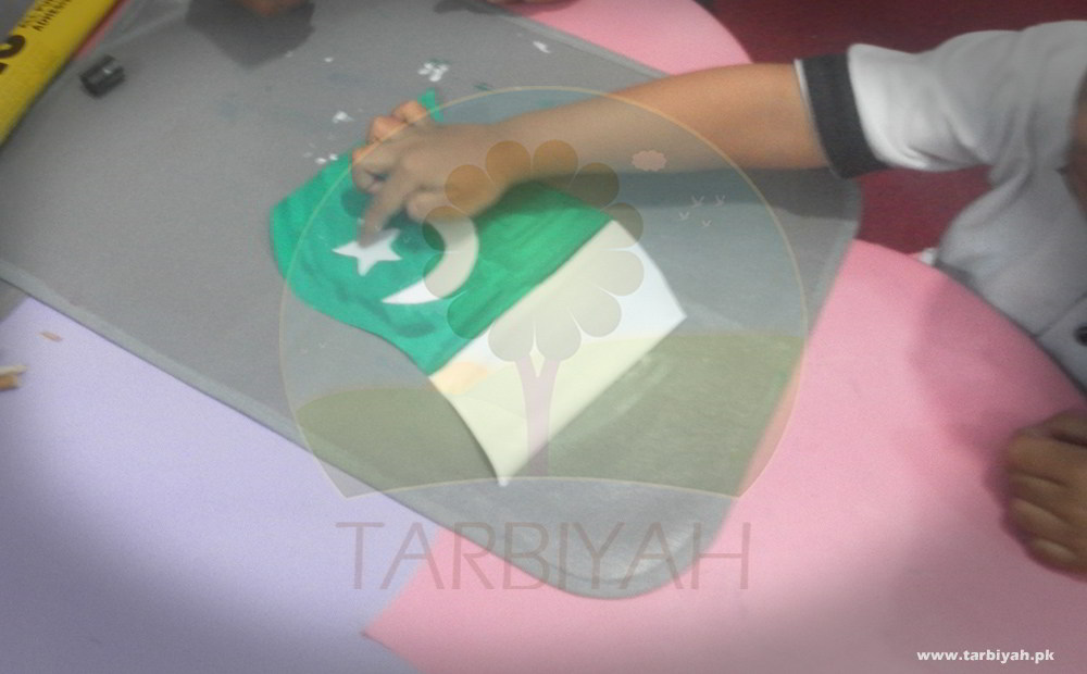Kid pasting moon on Pakistan flag